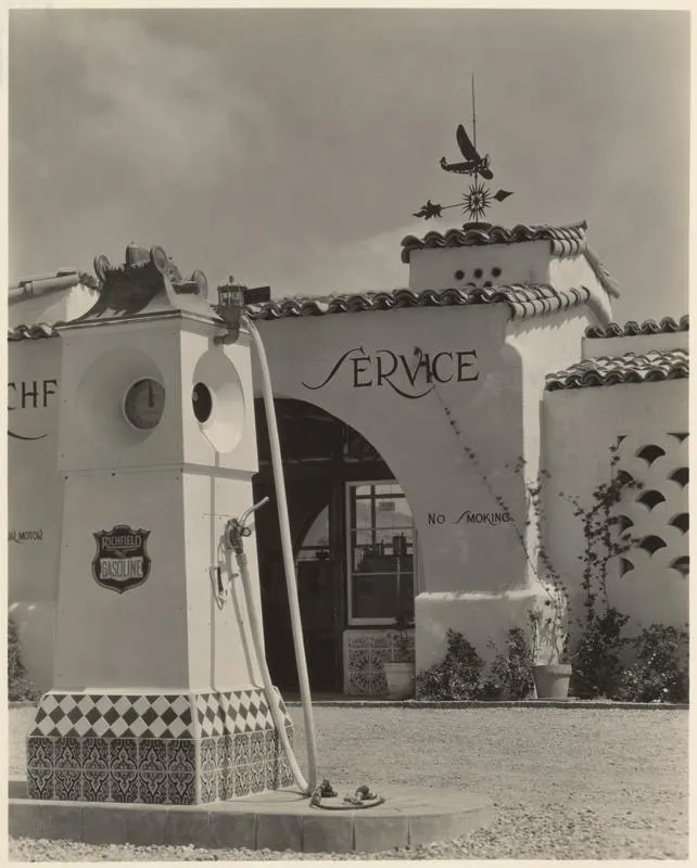 Historic photo of a gas pump in front of the Spanish-style Richfield station